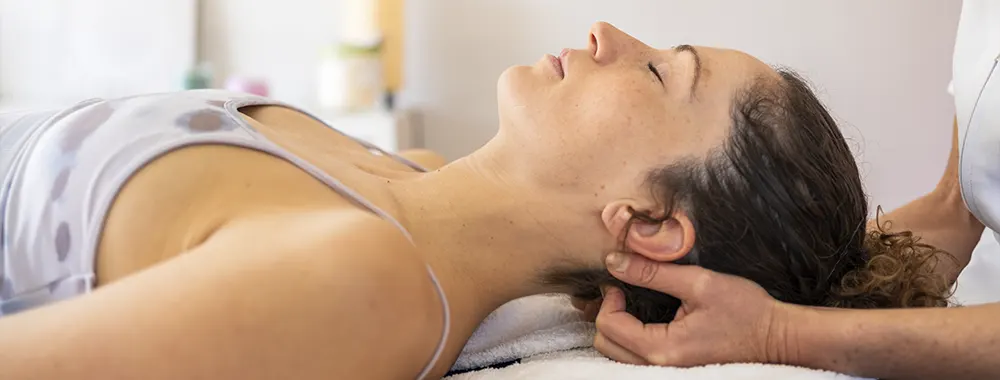 Female Client Lying on Bed and Having NUCCA Treatment