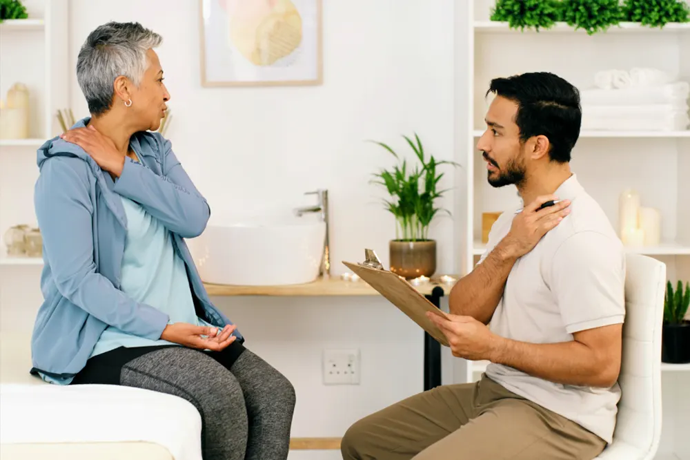 Patient discussing neck pain with chiropractor
